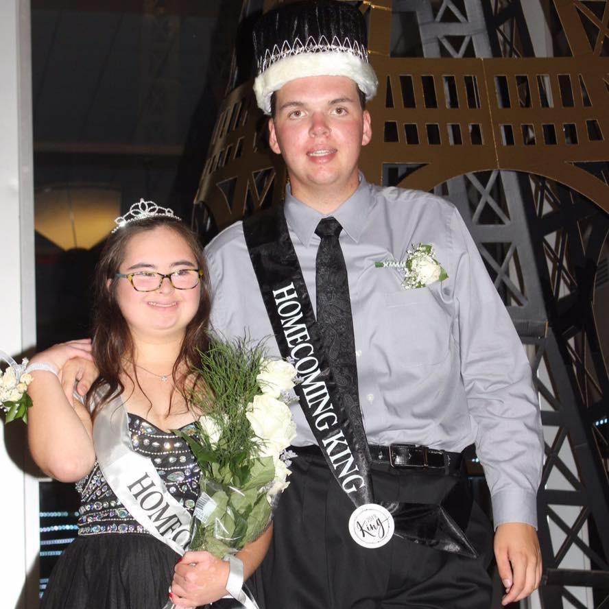 Seniors Luke Paugh and Ellie Townshend, the 2019 Homecoming King and Queen winners, pause on the stairs on Main Street in front of the Eiffel Tower for a photo.

