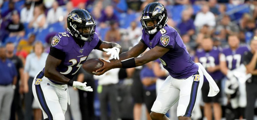 Quarterback Lamar Jackson hands the ball off to Running Back Gus Edwards during a home game at M&T Bank Stadium.