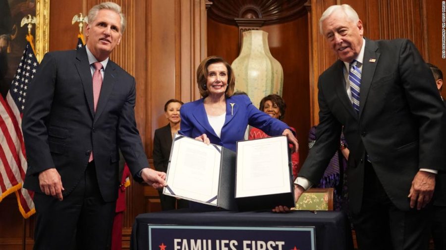 Speaker of the House Nancy Pelosi holds up the stimulus bill moments after being passed by the House.