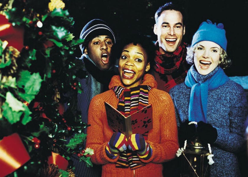 A group of people singing Christmas songs together. 
