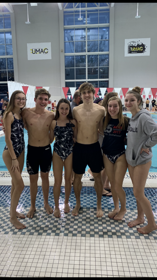 Swimmers on the Oakdale High School 2019 Swim Team pose in front of UMAC pool. 