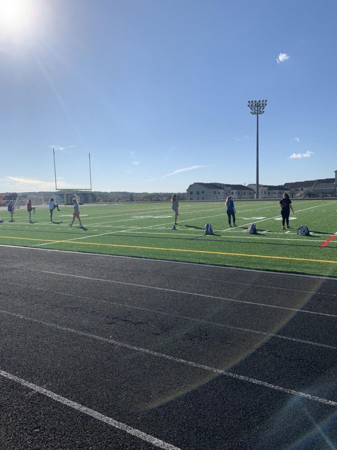 Girls track team is warming up on a sunny day to get ready for their season.  Everyone still socially distanced due to the regulation with return to play.
