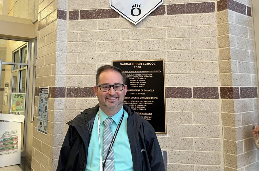 Mr.+Caulfield+under+the+Oakdale+Bears+Excellence+banner+in+the+schools+front+entrance%2C+where+he+spends+his+morning+greeting+students.