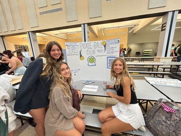 Pickle Ball club members take a picture with their club’s poster.