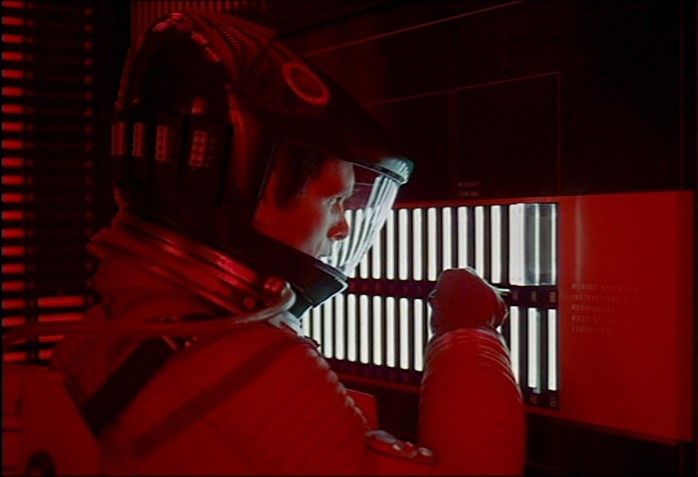 A frame from Stanley Kubrick and Arthur C. Clarke’s 2001: A Space Odyssey, featuring astronaut David Bowman (Keir Dullea) and the Artificial Intelligence known as HAL-9000 (Famously voiced by Douglas James Rain) as he attempts to disarm the villainous computer.