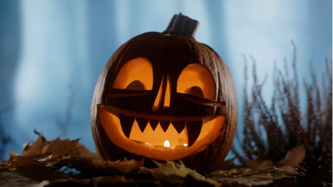 A+pumpkin+carved+with+a+face+lit+up+for+Halloween%21