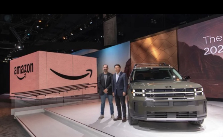 Marty Mallick (left) vice president of Amazon worldwide business and corporate development and CEO of Hyundai José Muñoz (right) pose in front of the new Hyundai car at the Los Angeles Auto Show. 