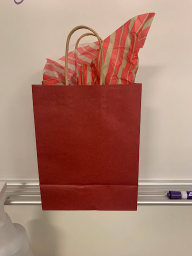 A festive gift bag that holds someones mystery gift.