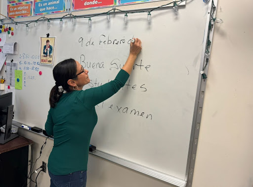 Señora Rosario writes instructions on the board for her students. 

