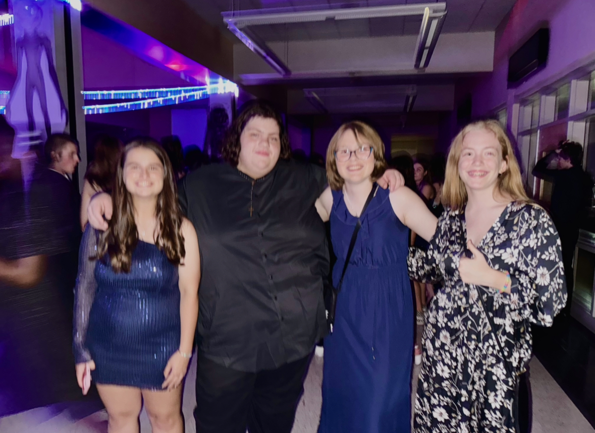 Freshmen Emily Gallas, Luis Reyes, Morgan Chlebda, and Harriet posing together on the dance floor at HOCO. 