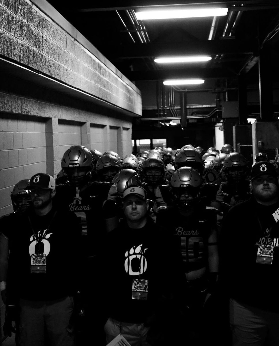 Oakdale’s football team and coaches gather in the tunnel before a game.