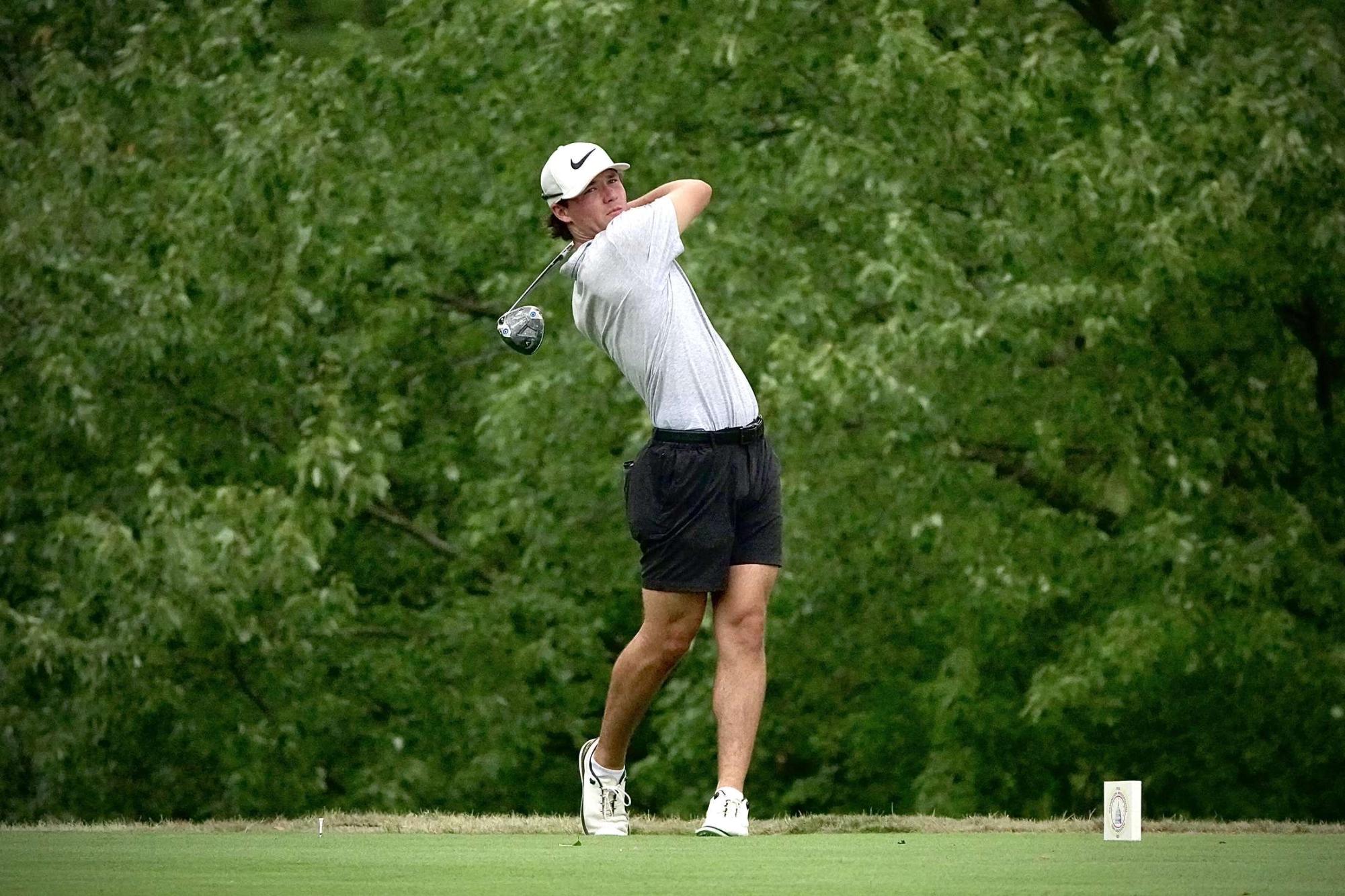 Zac Taylor hits the ball during a match, sending it soaring down the fairway.